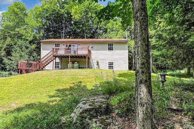 rear view of house with a deck and a lawn