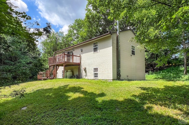 rear view of property featuring a lawn and a wooden deck