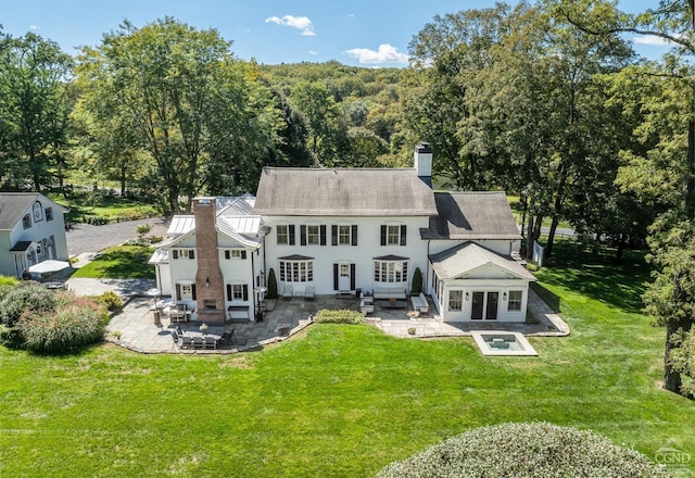 rear view of property featuring an outdoor hangout area, a patio area, and a yard