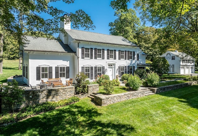 rear view of property with a patio area and a yard