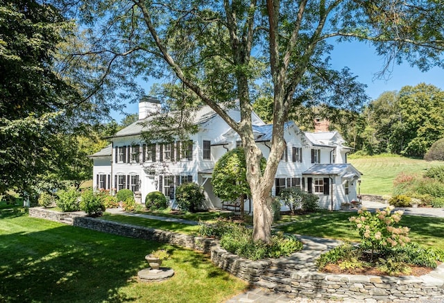 colonial-style house featuring a front yard