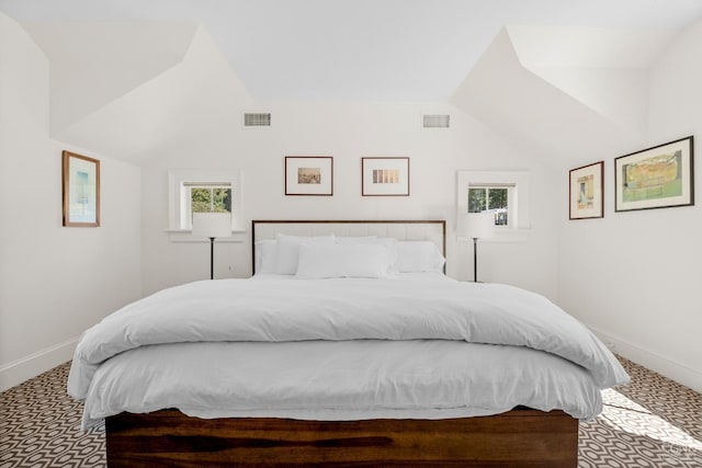 bedroom featuring carpet, lofted ceiling, and multiple windows