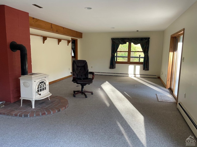 unfurnished room with carpet, a wood stove, and a baseboard heating unit