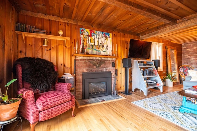 living area featuring wood ceiling, beamed ceiling, hardwood / wood-style floors, wooden walls, and a fireplace