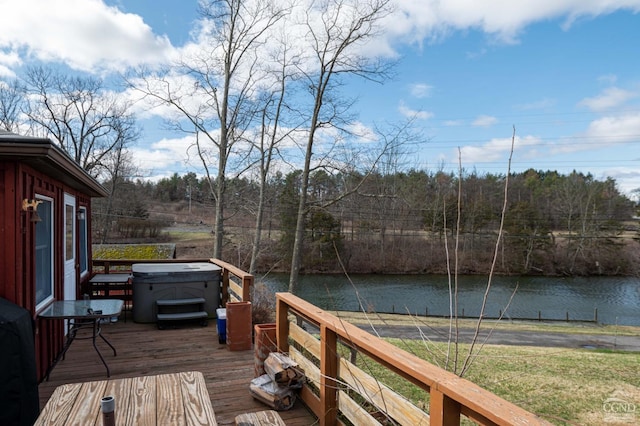 wooden deck featuring a water view and a hot tub