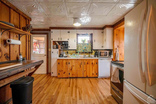 kitchen featuring appliances with stainless steel finishes, light countertops, light wood-style flooring, and a sink