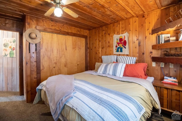 bedroom featuring wooden ceiling, wooden walls, a closet, and carpet flooring