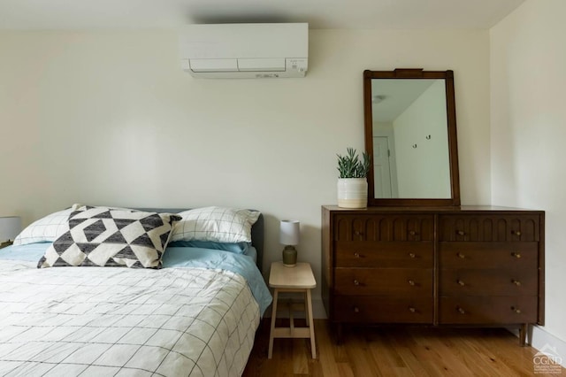 bedroom featuring an AC wall unit and wood finished floors