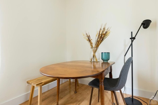 dining space with light wood-type flooring and baseboards