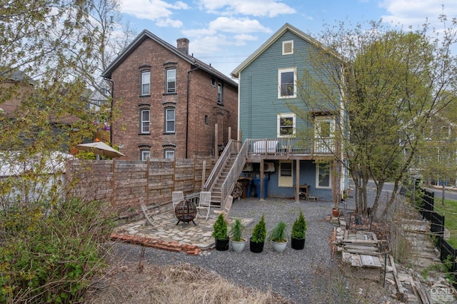 rear view of house featuring fence, stairs, an outdoor fire pit, a deck, and a patio area