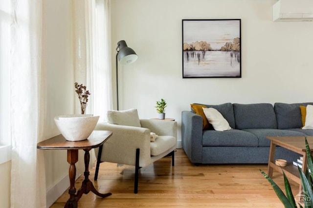 living room with light wood finished floors and a wall mounted AC