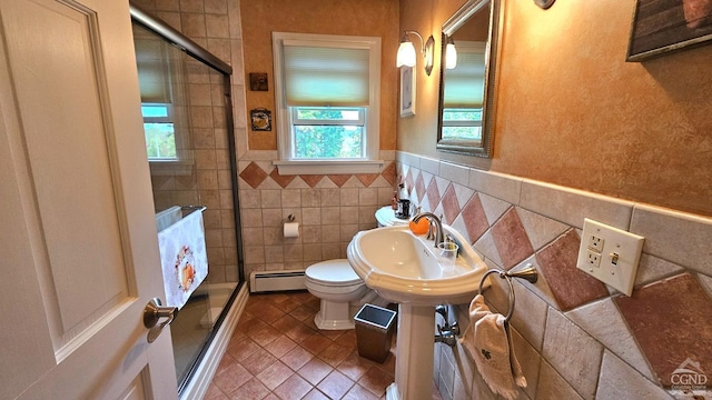 bathroom with a baseboard radiator, tile walls, an enclosed shower, and toilet