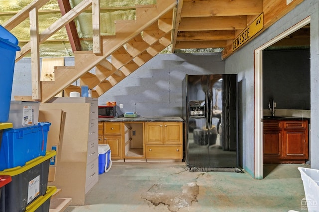 interior space featuring black fridge with ice dispenser and sink