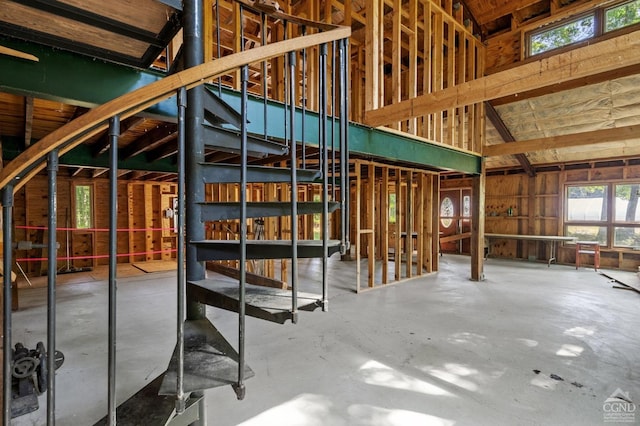 miscellaneous room with concrete flooring and lofted ceiling