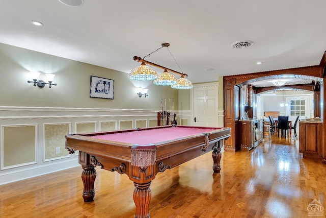 rec room with visible vents, arched walkways, light wood-style floors, and billiards