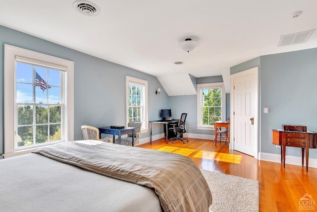 bedroom featuring visible vents, light wood-style flooring, and baseboards