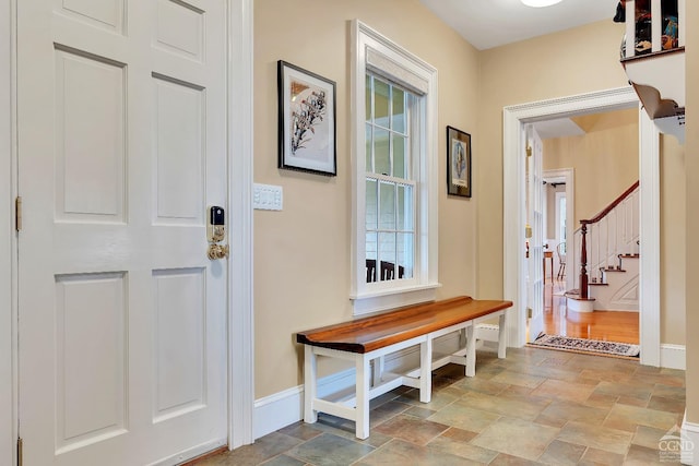 interior space with plenty of natural light, stone finish flooring, and baseboards