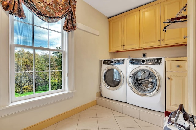 washroom featuring washer and clothes dryer, cabinet space, baseboards, and light tile patterned flooring