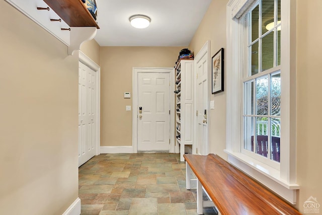 mudroom with baseboards and stone finish flooring