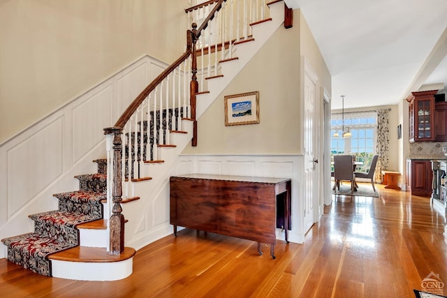 staircase with a decorative wall and wood finished floors