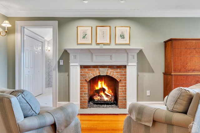 living room featuring wood finished floors, crown molding, a fireplace, and baseboards