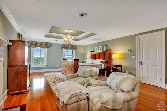 bedroom featuring visible vents, an inviting chandelier, crown molding, light wood finished floors, and a raised ceiling