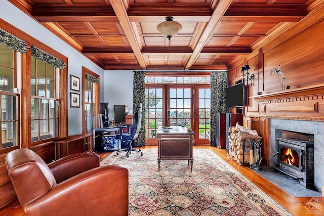 office space with crown molding, beam ceiling, light wood-style flooring, wooden ceiling, and coffered ceiling