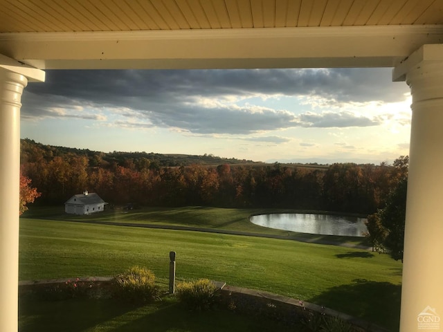 surrounding community featuring a lawn and a wooded view