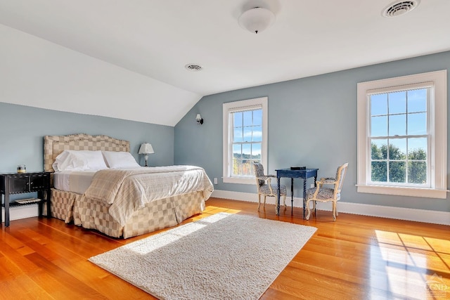 bedroom with multiple windows, visible vents, and light wood finished floors