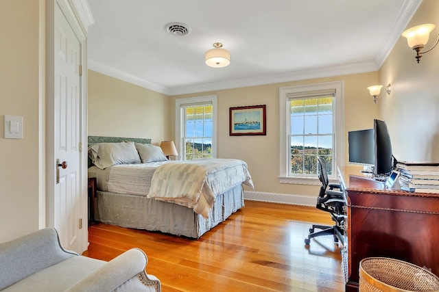 bedroom featuring crown molding, wood finished floors, visible vents, and baseboards