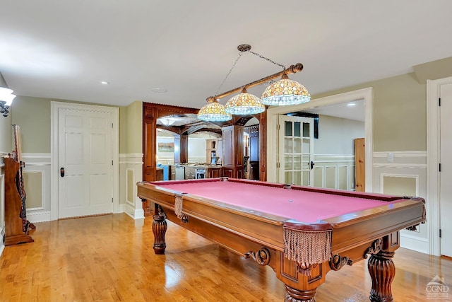 rec room featuring pool table, a decorative wall, wood finished floors, and a wainscoted wall