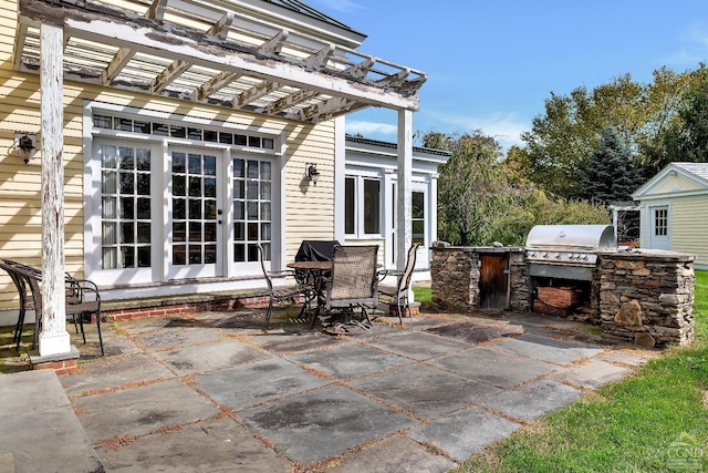 view of patio / terrace with area for grilling, french doors, and a pergola