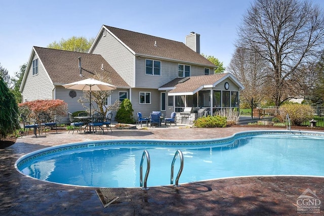view of pool featuring a fenced in pool, a sunroom, and a patio area