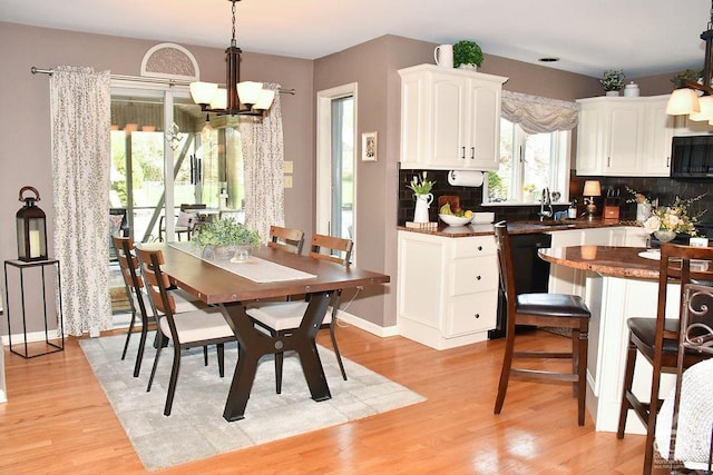 dining space featuring light wood-style floors and a notable chandelier