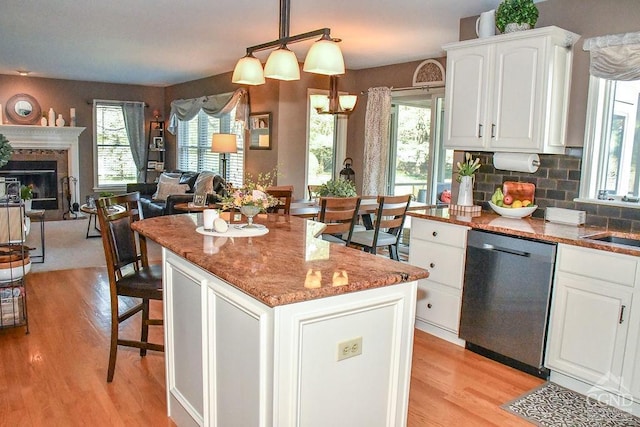 kitchen with white cabinets, open floor plan, light wood-style flooring, and dishwasher