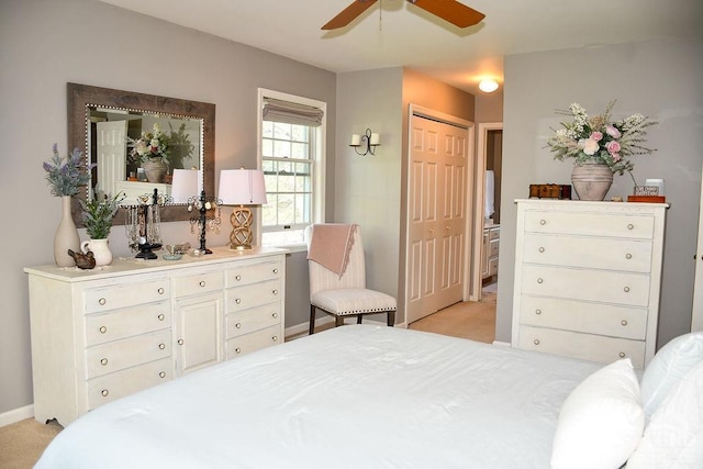 bedroom featuring baseboards, a ceiling fan, a closet, and light carpet