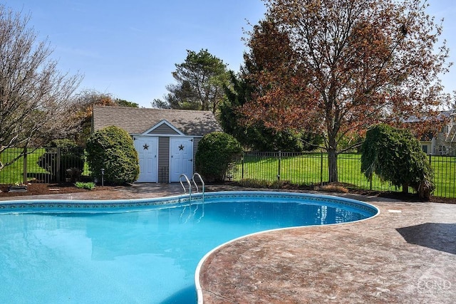 view of swimming pool with fence, a fenced in pool, an outdoor structure, a shed, and a yard