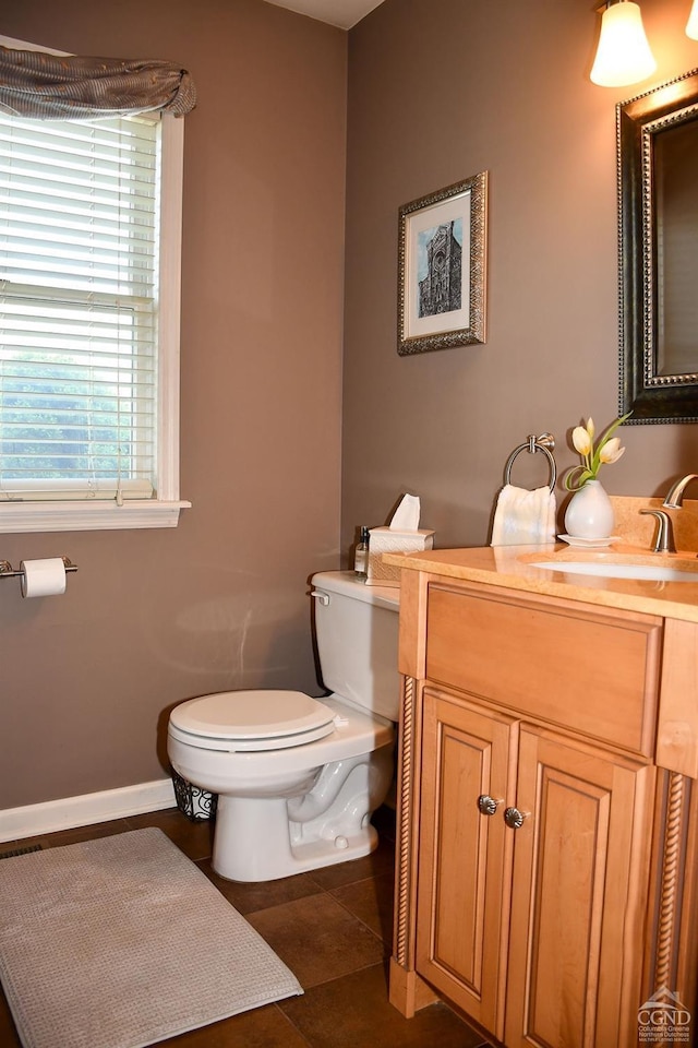 half bath with vanity, baseboards, and toilet