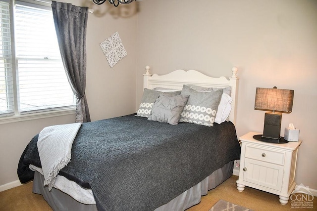 bedroom with baseboards and light carpet