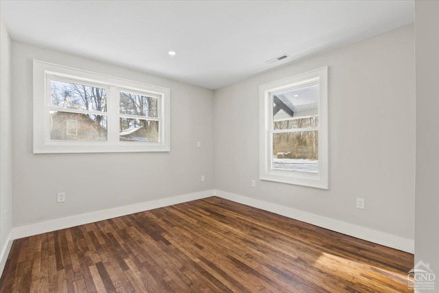 spare room featuring dark wood finished floors, visible vents, recessed lighting, and baseboards