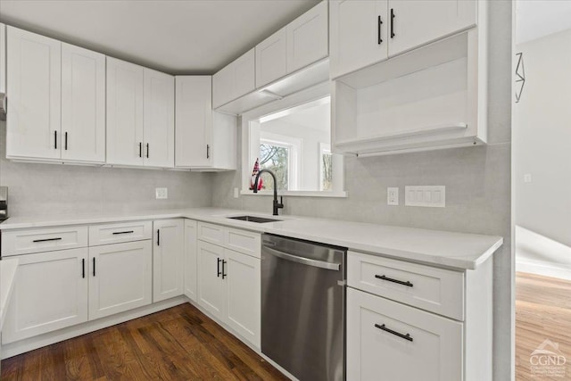 kitchen featuring dark wood finished floors, light countertops, stainless steel dishwasher, white cabinets, and a sink