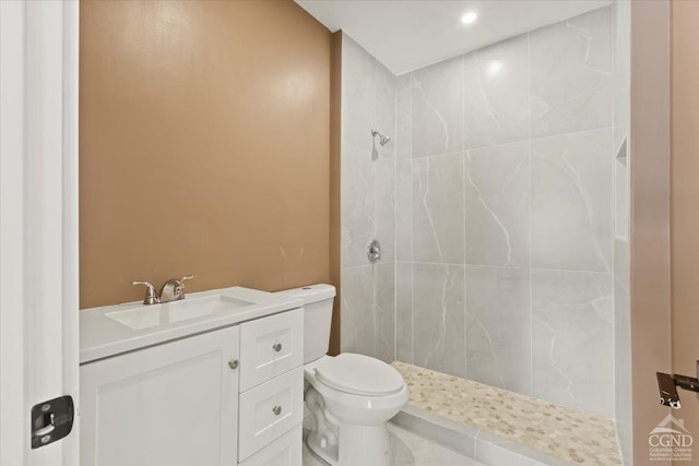 full bathroom with vanity, toilet, and tiled shower