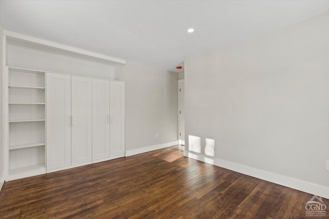 unfurnished bedroom with a closet, recessed lighting, baseboards, and wood finished floors