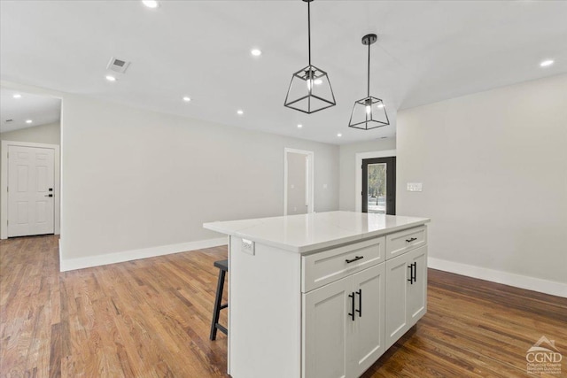 kitchen featuring recessed lighting, white cabinets, a kitchen island, and wood finished floors