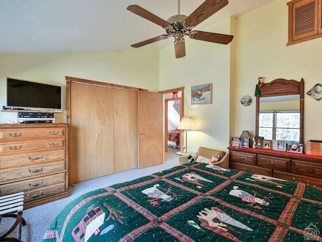 bedroom with light carpet, vaulted ceiling, a closet, and ceiling fan