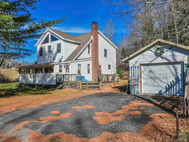 view of front of home featuring an outbuilding, a garage, and a wooden deck