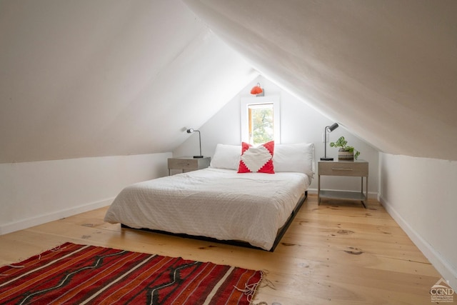 bedroom featuring vaulted ceiling, wood finished floors, and baseboards