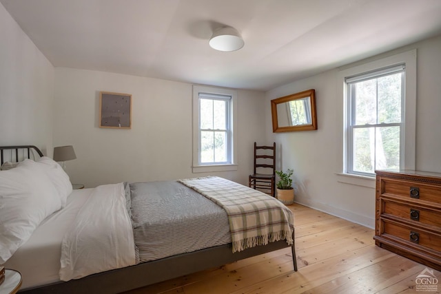 bedroom with light wood-style flooring and baseboards