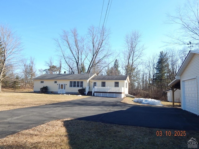 ranch-style home featuring a front lawn, a garage, and driveway