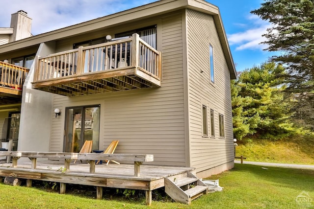 back of house with a lawn, a balcony, and a deck